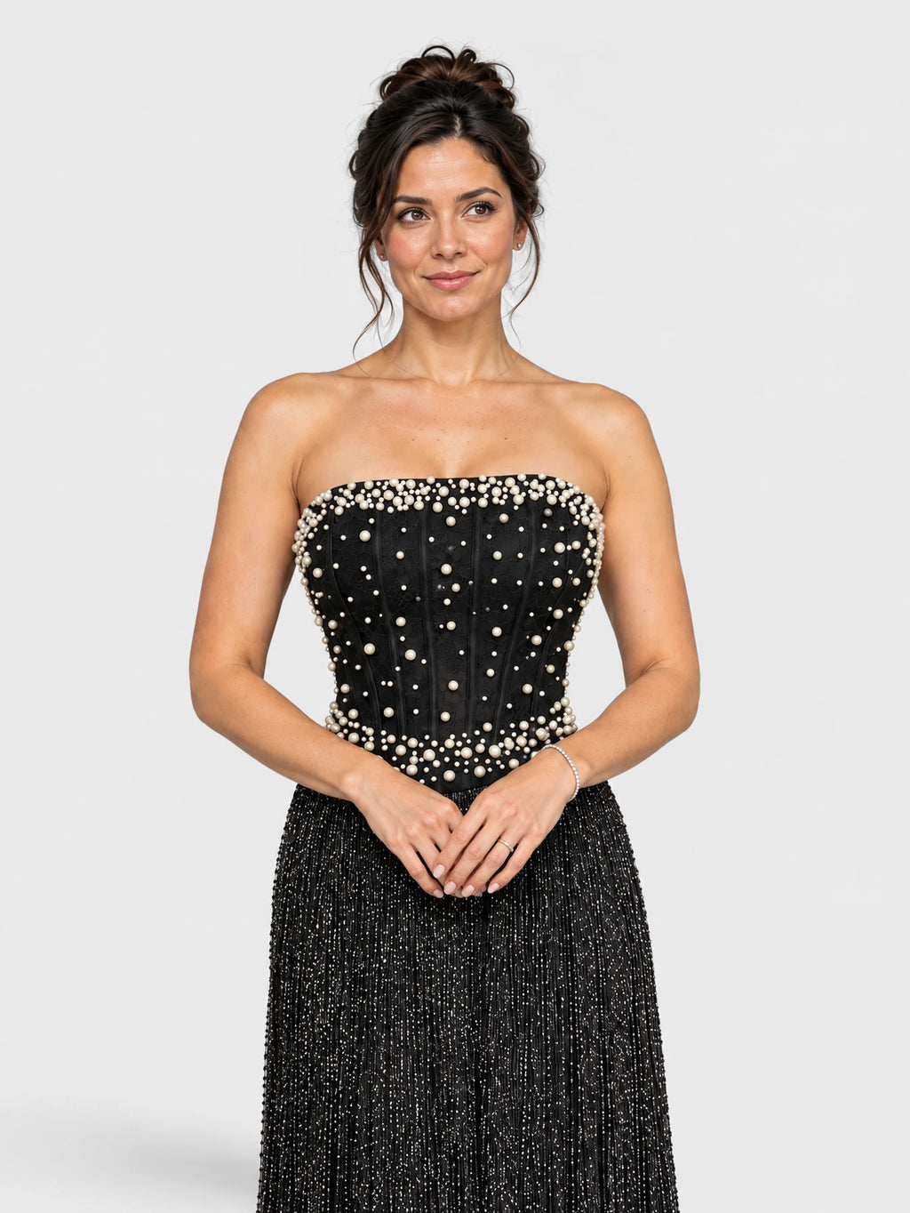 Detalhe do bordado e dos apliques de pérolas no vestido de festa longo preto.