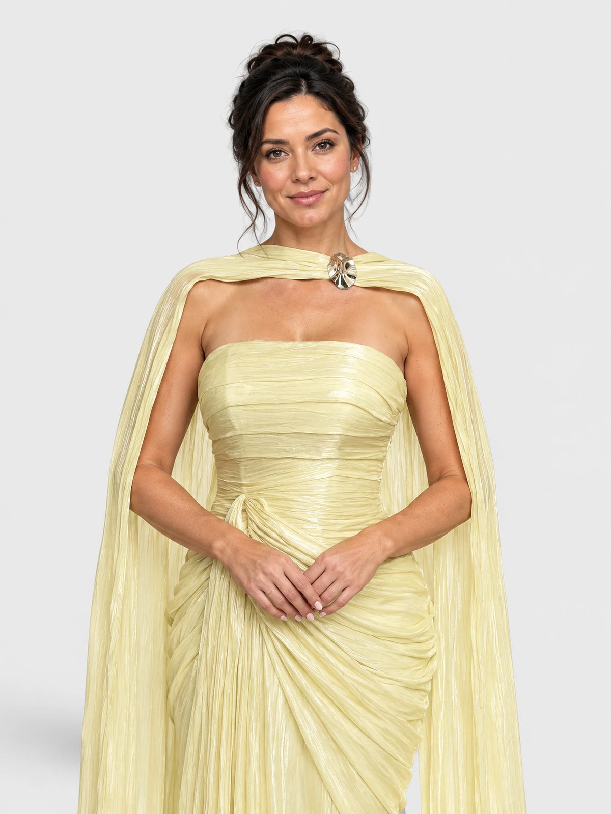 Detalhe do acabamento drapeado e da echarpe metalizada no vestido longo amarelo.