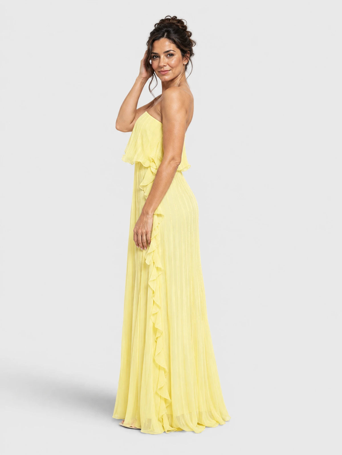 Vestido de festa amarelo tomara que caia plissado, visto de lado.